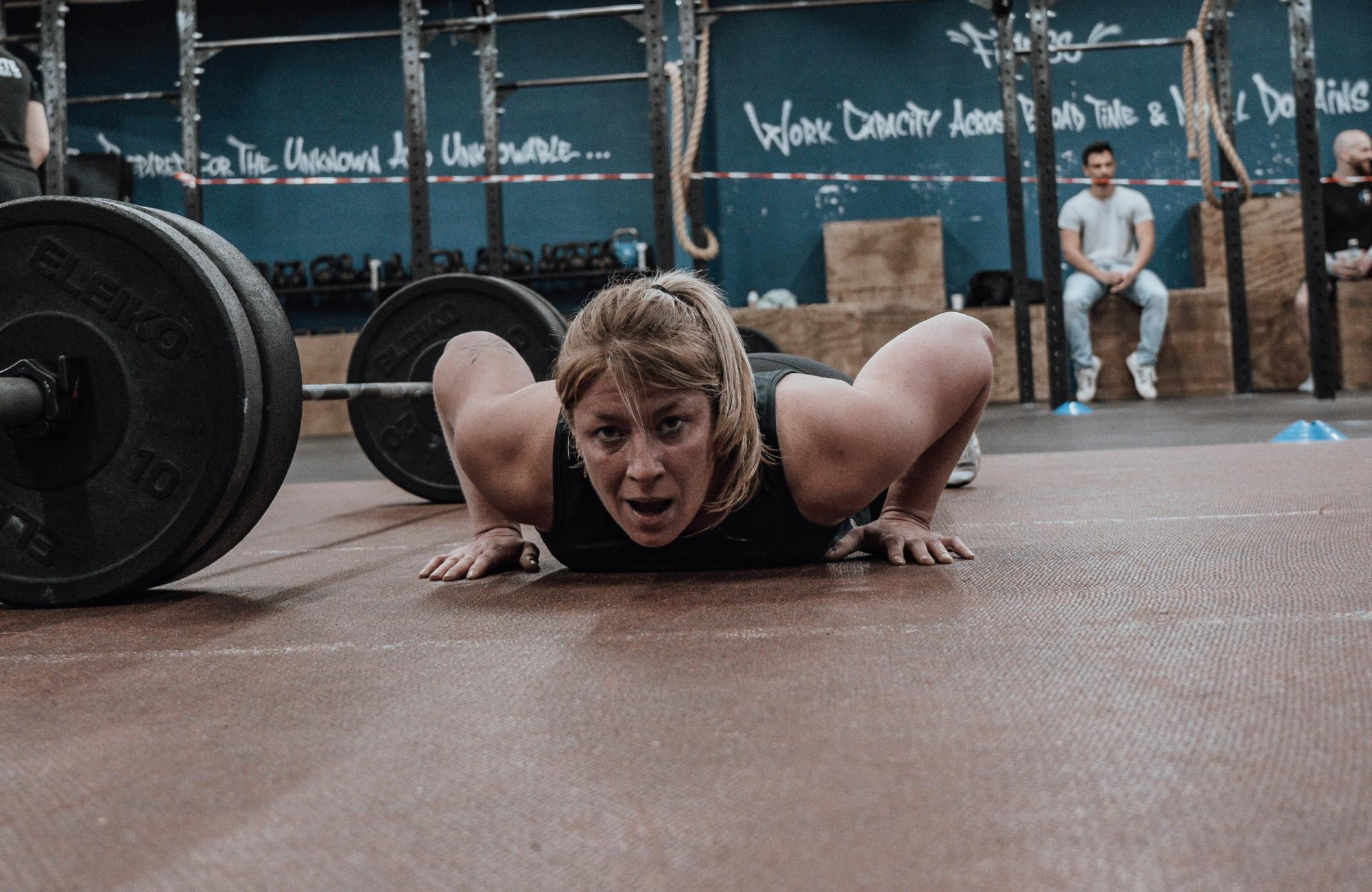 Perimenopause & Krafttraining Frau in den Wechseljahren macht einen Plank im Fitnessstudio
